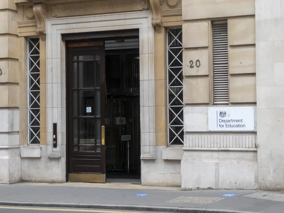 The entrance to No 3 Sanctuary Buildings in London: a dark wooden door in a pale stone front, with a Department for Education sign on the wall beside it
